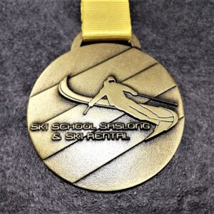 medaglia personalizzata scuola sci saslong in metallo a rilievo 2D finitura bronzo antico con nastro personalizzato in serigrafia
