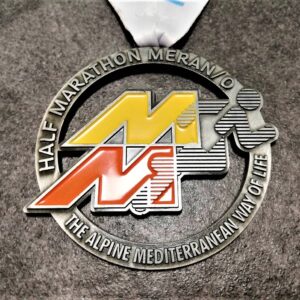 medaglia personalizzata half marathon merano 2019 in metallo a rilievo 2D traforata con smalti finitura argento antico con nastro personalizzato in sublimazione