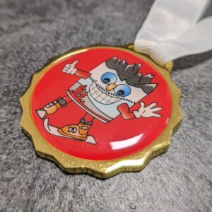 custom san candido ski school medal in gold finish silk screen printed metal with lens effect and personalized screen printed ribbon side view