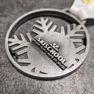 custom skischool seiser alm alpe di siusi medal in 2D metal embossing without enamel antique silver finish with personalized sublimation ribbon side view